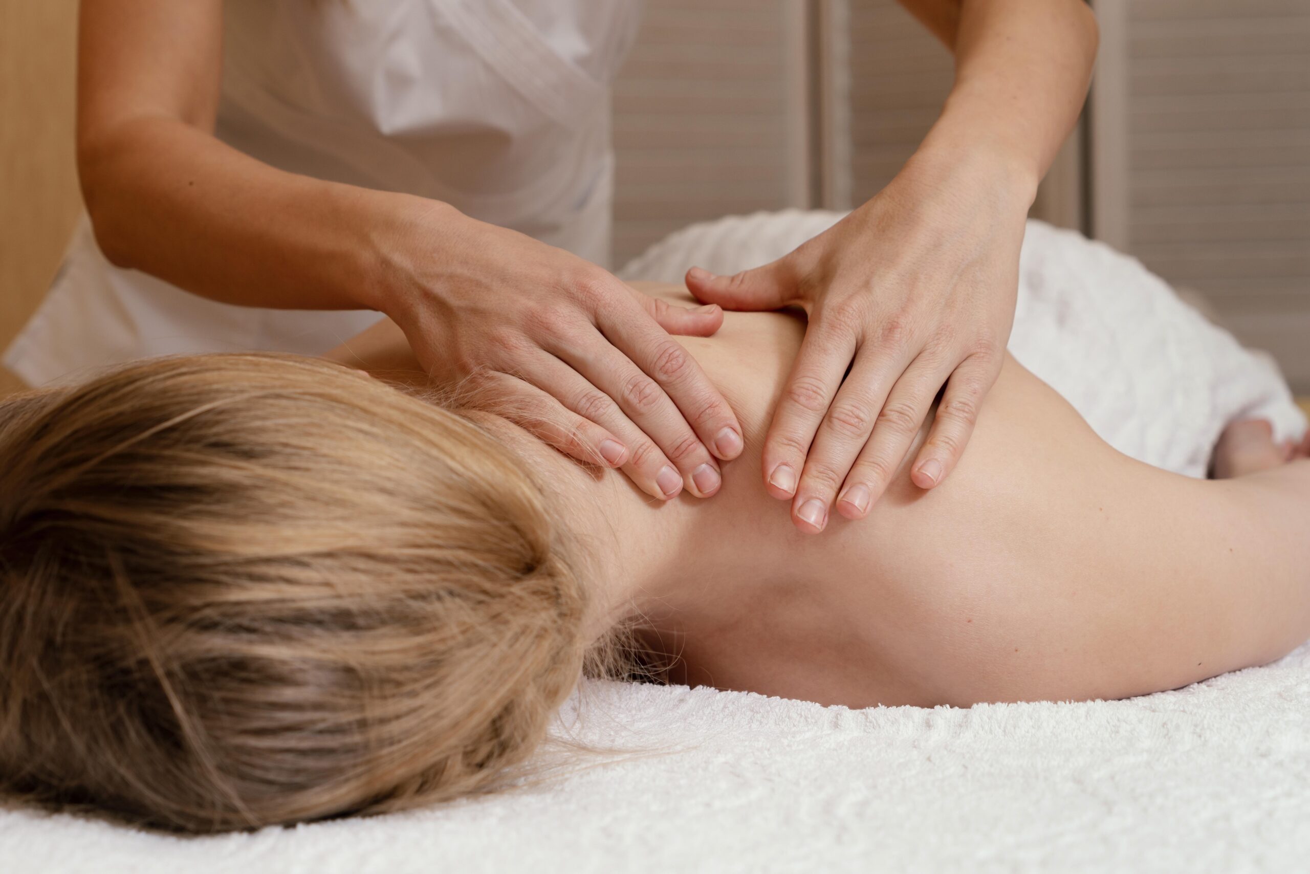 close up hands massaging woman's back